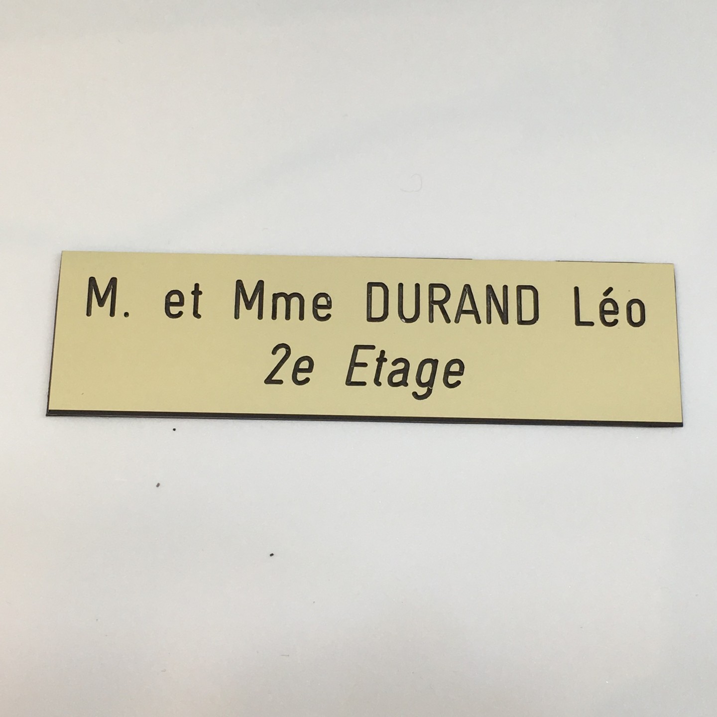 Plaque de boîte aux lettres, fond beige, texte gravé noir