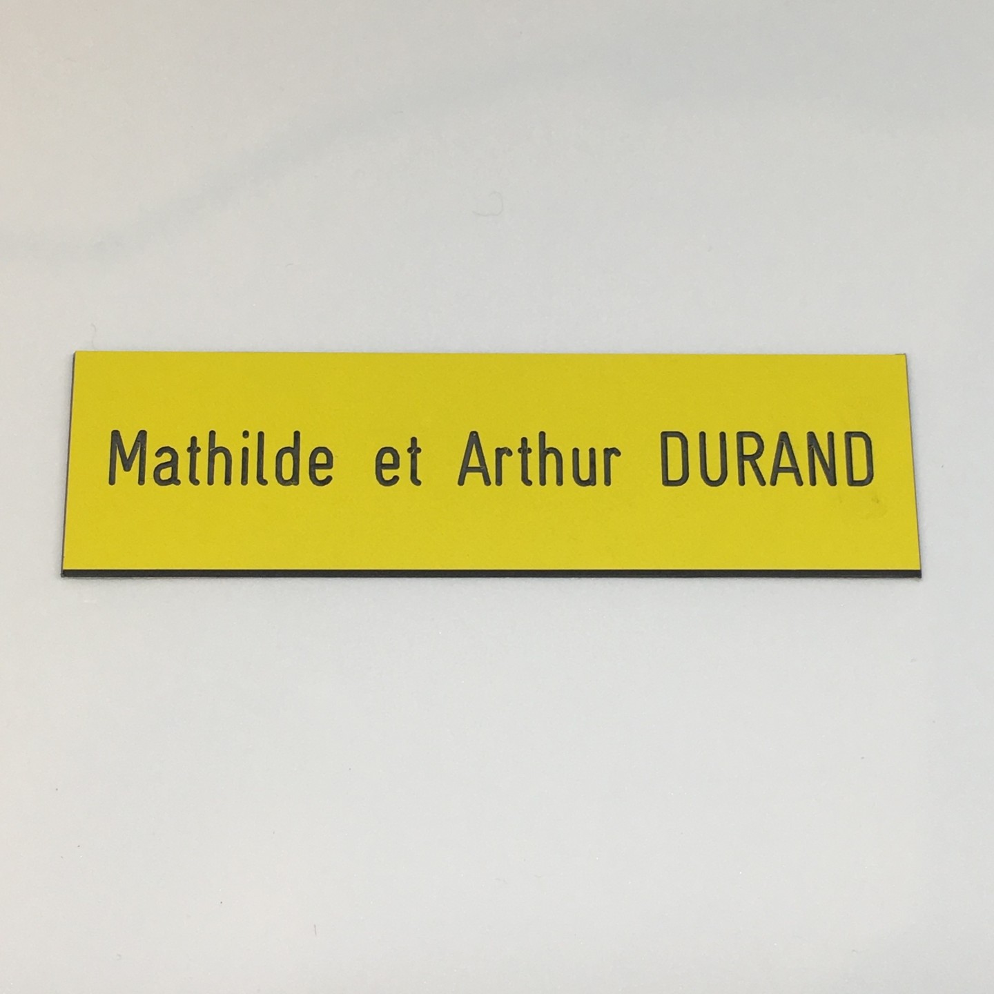 Plaque de boîte aux lettres, fond jaune, texte gravé noir